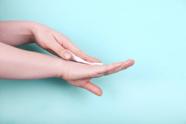 Kadın ellerini beyaz yumuşak kağıt mendille temizleyip sterilize ediyor..