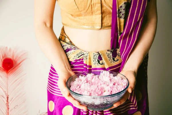 Indian Woman Wearing Sari and Holding Basket of Pink flowers
