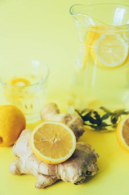 Sarı arka planda limonlu, naneli ve zencefilli su. Sağlıklı bir içki. Alternatif ilaçlar