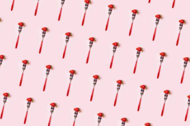 Pembe arka planda kırmızı çatal desenli bir çilek. Üst Manzara. Dikey. Diyet asgari konsepti.