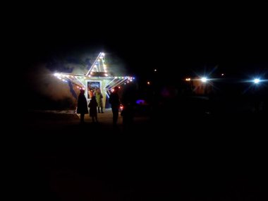 Night city. Festive illumination. People relax in the recreation Park.