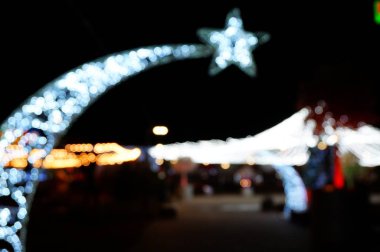 Arka plan bulanık. Şehirde Noel süslemeleri. Geceleri şenlikli aydınlanma.