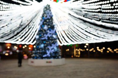 Arka plan bulanık. Şehirde Noel süslemeleri. Geceleri şenlikli aydınlanma.
