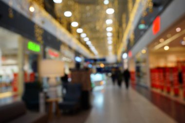 Blurred background. Shopping center gallery. People buy products.