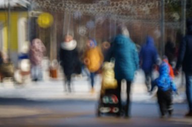 Arka plan bulanık. Şehrin sokaklarında insanlar.