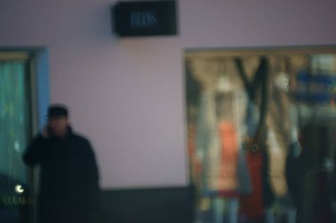 Arka plan bulanık. İnsanlar şehrin caddesi boyunca yürür. Şehir hayatı. Kalabalığın hareketi. İnsan siluetleri. Aile tatili. İşadamı.