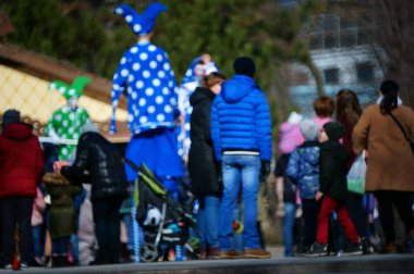 Arka plan bulanık. İnsanlar eğlence parkında yürüyor..