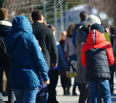 Arka plan bulanık. İnsanlar eğlence parkında yürüyor..