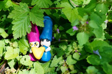 Kil içinden bir kalp tutan iki cüce. Güzel renkli bir arka planda harika figürler..