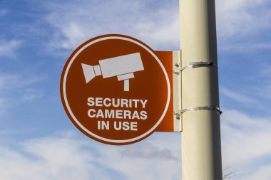 Turuncu güvenlik kamera kullanım işareti gri yazı ve kısmen güneşli arka plan II