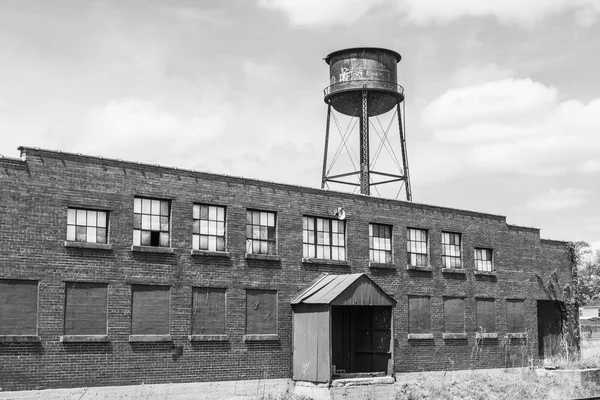 Verlassenes Rostgürtel-Autohaus und Fabrik mit Wasserturm - verschlissen, kaputt und vergessen — Stockfoto