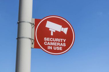 Kırmızı güvenlik kamera kullanım işareti gri yazı ve çoğunlukla güneşli arka plan VI