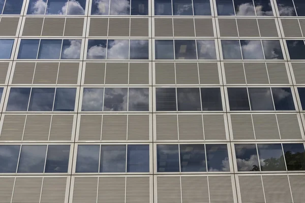Ft. Wayne - Por volta de agosto de 2017: Lado de um prédio de arranha-céus com painéis cinza e janelas que refletem o céu com nuvens I — Fotografia de Stock