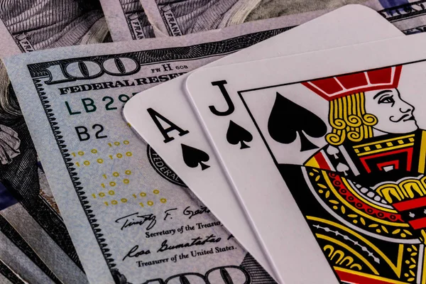 Primer plano de una mano de Blackjack 21 en una cama de billetes de cien dólares III — Foto de Stock