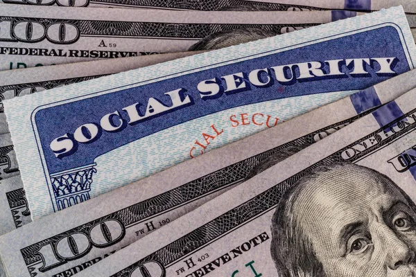 Social Security-kort och en bädd av pengar som representerar höga levnadskostnaderna på en fast inkomst Ii — Stockfoto