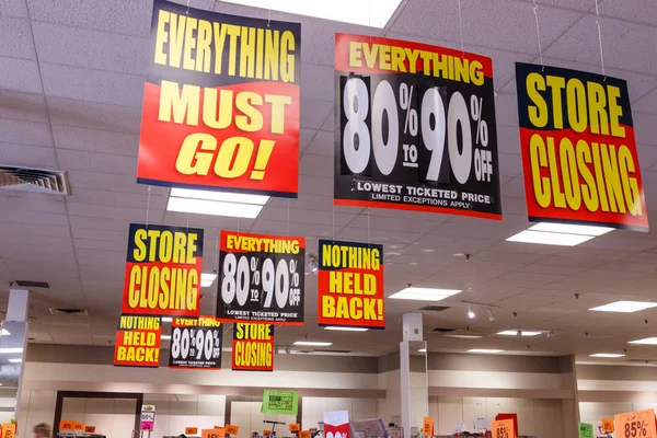 Store Closing and huge discount signs displayed at a soon to be out of business sale I