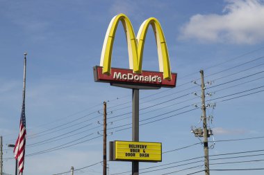 Indianapolis - Circa April 2020: McDonald's Restaurant. McDonald's is offering Uber and Door Dash delivery and drive thru service during social distancing. clipart