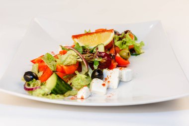 Yunan salatası yakın kadar beyaz peynir, domates, zeytin ve yeşil yapraklar