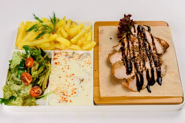 Grilled meat with sauce, salad and French fries