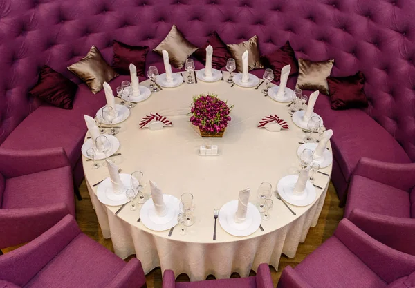 Украшенный круглым столом с фиолетовыми креслами Стоковая Картинка