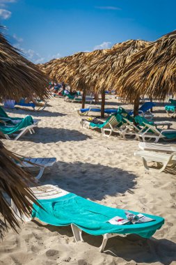 Straw huts serve as shelters on the sunny beach
