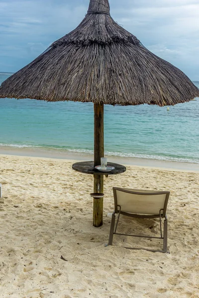 Солом'яна хатина і порожній стілець на піщаному пляжі — стокове фото
