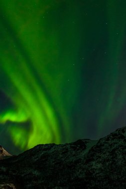 Kuzey Avrupa 'nın kuzeyindeki dağların üzerinden, Norveç' in kuzeyindeki Lofoten Adaları 'ndan inanılmaz Aurora Borealis.