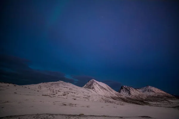 Noche dramática con muchas nubes y estrellas en el cielo sobre las montañas en el norte de Europa - Tromso, Noruega.larga velocidad de obturación . — Foto de Stock