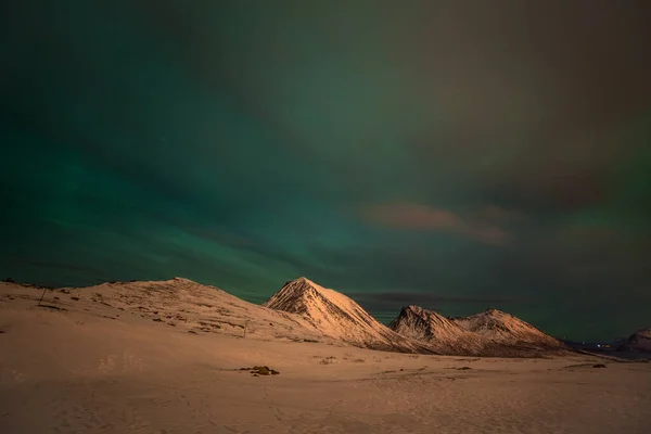 Drámai sarki fények, Aurora borealis sok felhők és csillagok az égen a hegyek felett Észak-Európában - Tromso, Norvégia.hosszú záridő. — Stock Fotó
