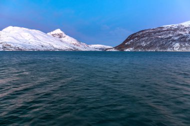 Norveç 'in Fiyort Tromso üzerinde muhteşem eflatun rengi ile muhteşem bir günbatımı. Kutup gecesi. uzun deklanşör hızı