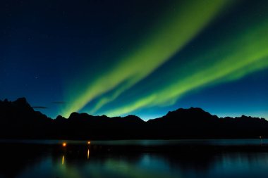 Kuzey Avrupa 'daki Lofoten adaları, Norveç' teki dağların üzerinden dramatik aurora borealis, kutup ışıkları.