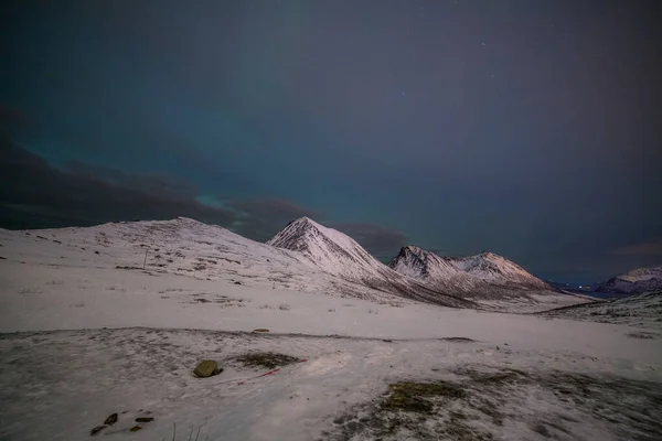 Noche dramática con muchas nubes y estrellas en el cielo sobre las montañas en el norte de Europa - Tromso, Noruega.larga velocidad de obturación . — Foto de Stock