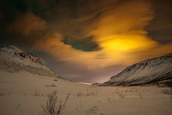 Luces polares dramáticas, Aurora boreal con muchas nubes y estrellas en el cielo sobre las montañas en el norte de Europa - Tromso, Noruega.Larga velocidad de obturación . — Foto de Stock