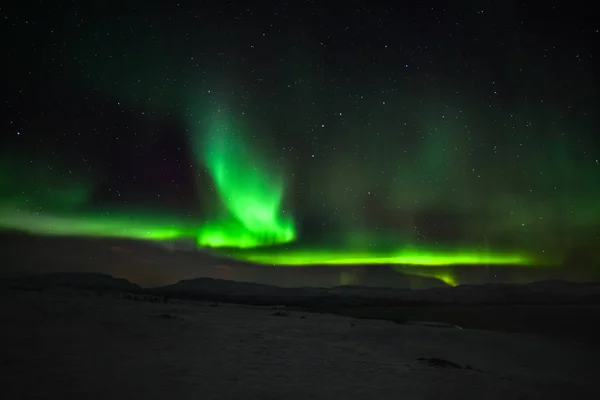 Luces polares dramáticas, Aurora boreal con muchas nubes y estrellas en el cielo sobre las montañas en el norte de Europa Abisko, Suecia. larga velocidad de obturación . — Foto de Stock