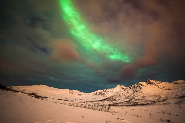 Drámai sarki fények, Aurora borealis sok felhők és csillagok az égen a hegyek felett Észak-Európában - Tromso, Norvégia.hosszú záridő. — Stock Fotó