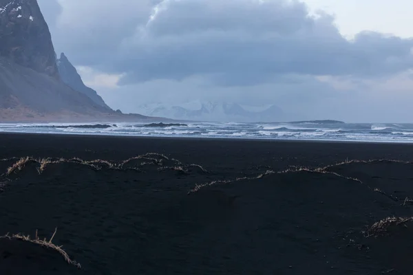 Islandia, monte Vestrahorn y arena negra sobre el océano . — Foto de Stock