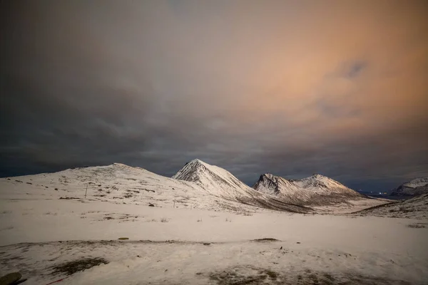 Noche dramática con muchas nubes y estrellas en el cielo sobre las montañas en el norte de Europa - Tromso, Noruega.larga velocidad de obturación . — Foto de Stock