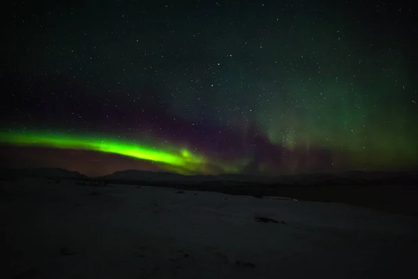 Luces polares dramáticas, Aurora boreal con muchas nubes y estrellas en el cielo sobre las montañas en el norte de Europa Abisko, Suecia. larga velocidad de obturación . — Foto de Stock