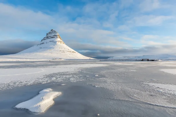 Un bellissimo torrente e Kirkjufell montagna coperta di neve durante l'inverno in Islanda . — Foto Stock