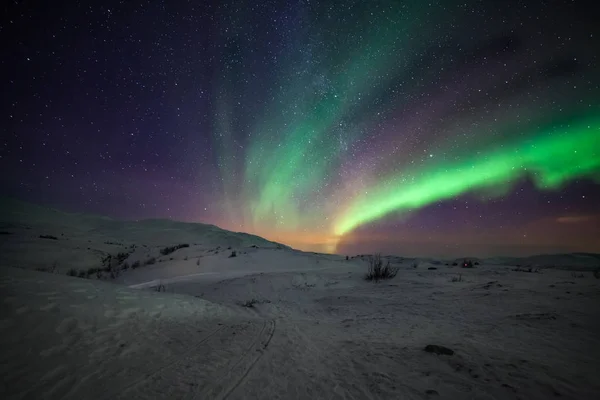 극적 인 극광인 오로라 보렐리스는 유럽 북부 의산 위로 하늘에 떠 있는 많은 구름 과 별들을 가지고 있는데, 이것은 스웨덴의 비스코입니다. 긴 셔터 속도. — 스톡 사진