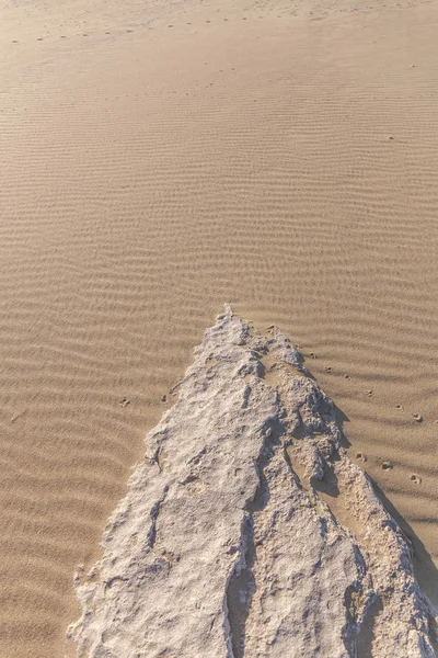 砂から突き出た石。砂の質感。細砂の背景. — ストック写真