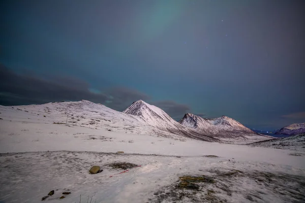 Noche dramática con muchas nubes y estrellas en el cielo sobre las montañas en el norte de Europa - Tromso, Noruega.larga velocidad de obturación . — Foto de Stock