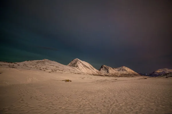 Noche dramática con muchas nubes y estrellas en el cielo sobre las montañas en el norte de Europa - Tromso, Noruega.larga velocidad de obturación . — Foto de Stock