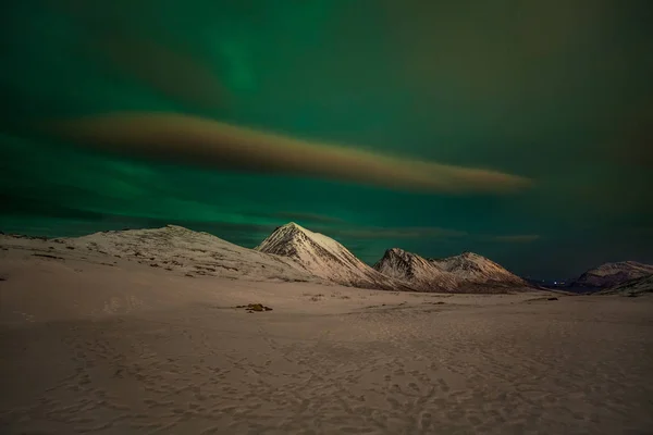 Luces polares dramáticas, Aurora boreal con muchas nubes y estrellas en el cielo sobre las montañas en el norte de Europa - Tromso, Noruega.Larga velocidad de obturación . — Foto de Stock