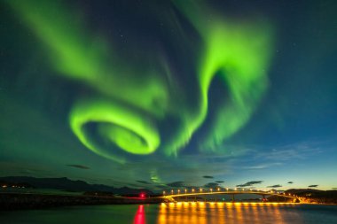 Dramatic aurora borealis, polar lights, over mountains in the North of Europe - Lofoten islands, Norway clipart