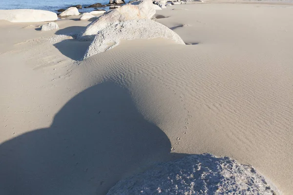 Pedras a sair da areia. Textura de areia. Contexto da areia fina . — Fotografia de Stock