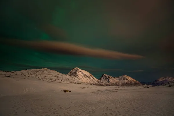 Drammatiche luci polari, Aurora boreale con molte nuvole e stelle sul cielo sopra le montagne del Nord Europa - Tromso, Norvegia. . — Foto Stock