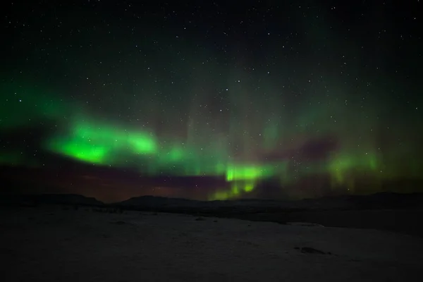 Luces polares dramáticas, Aurora boreal con muchas nubes y estrellas en el cielo sobre las montañas en el norte de Europa Abisko, Suecia. larga velocidad de obturación . — Foto de Stock