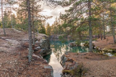 Güneşli bir akşamda mavi zümrüt suyuyla terk edilmiş eski gümüş madeni. İsveç 'te Silverberg. seçici odak