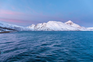 Norveç 'in Fiyort Tromso üzerinde muhteşem eflatun rengi ile muhteşem bir günbatımı. Kutup gecesi. uzun deklanşör hızı